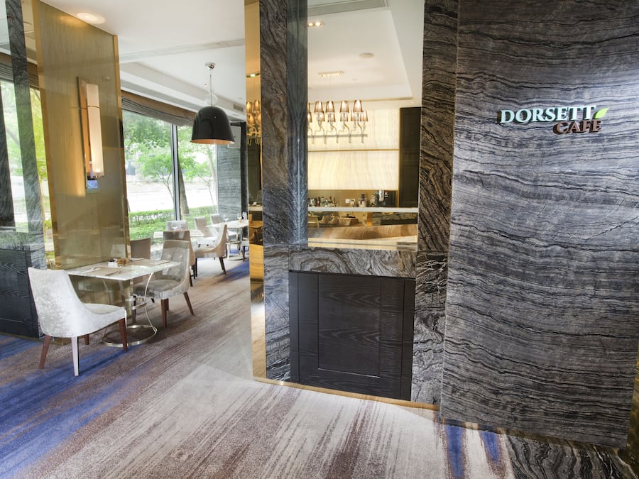 A modern interior with a dining area, a bar, and a kitchen visible through a glass partition.