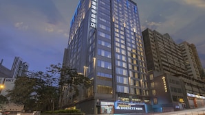 Un hotel de gran altura con varios pisos, ventanas amplias y un letrero llamativo del hotel Dorsey.