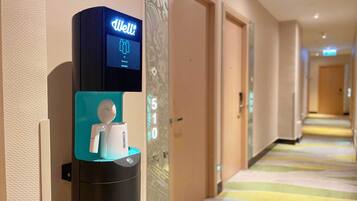 Un dispensador de agua digital con pantalla en un pasillo de hotel.