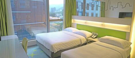 A hotel room with two beds, a desk, and a large window offering a city view.