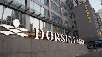 Um edifício moderno com grandes janelas de vidro e uma placa chamativa com a inscrição 'DORSETT'.