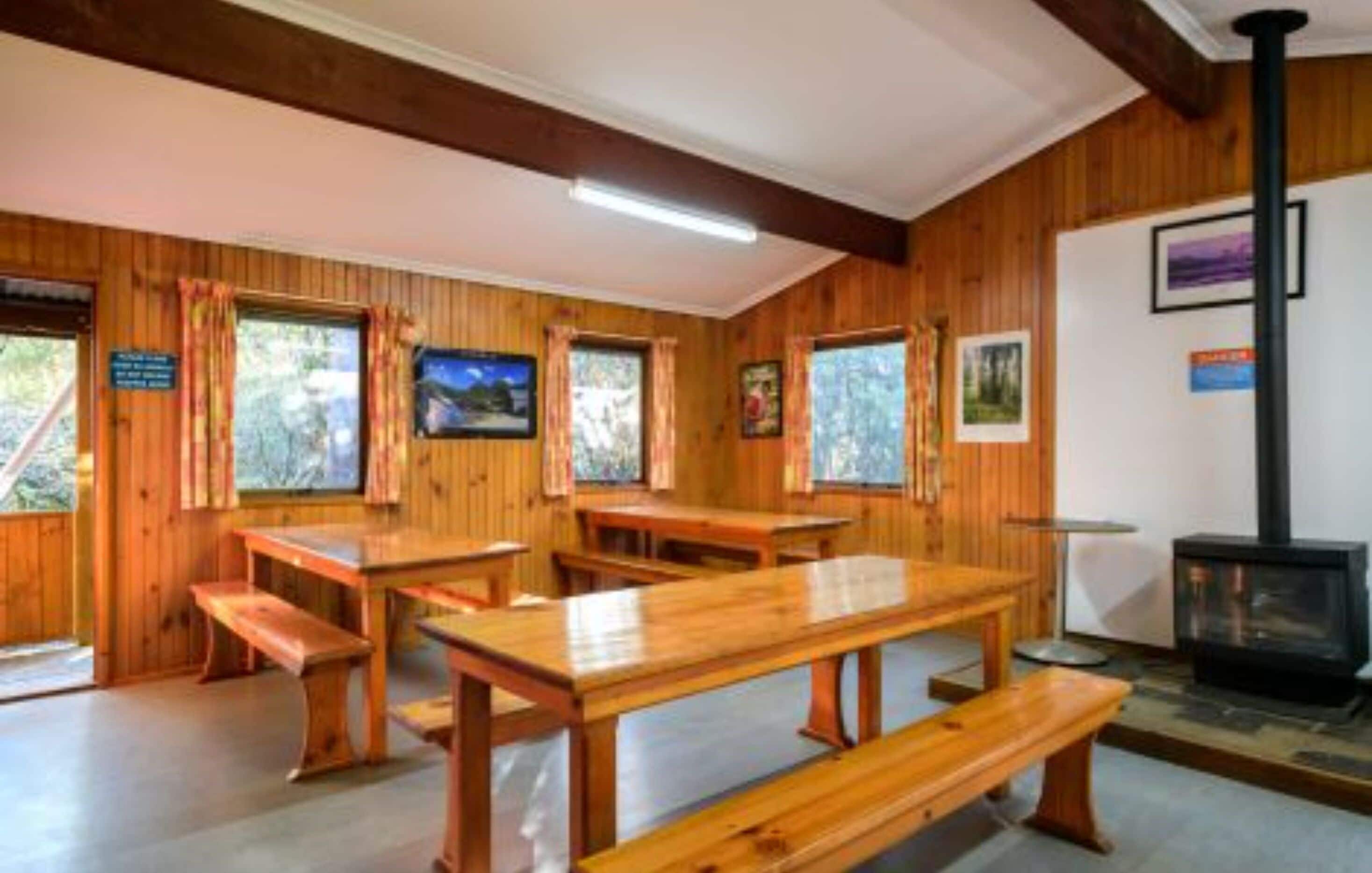 Un intérieur en bois avec des bancs et une cheminée.