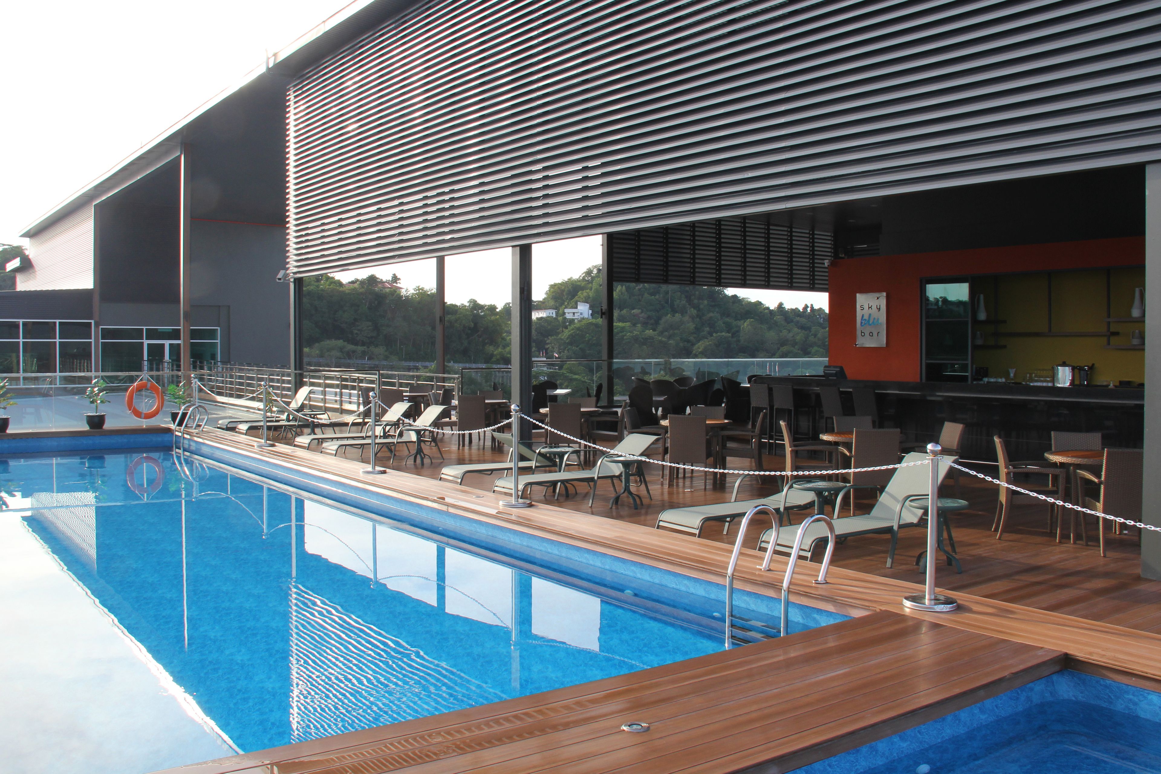 A swimming pool with lounge chairs and a bar area.