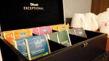A black box with compartments containing various tea bags and a coffee maker.