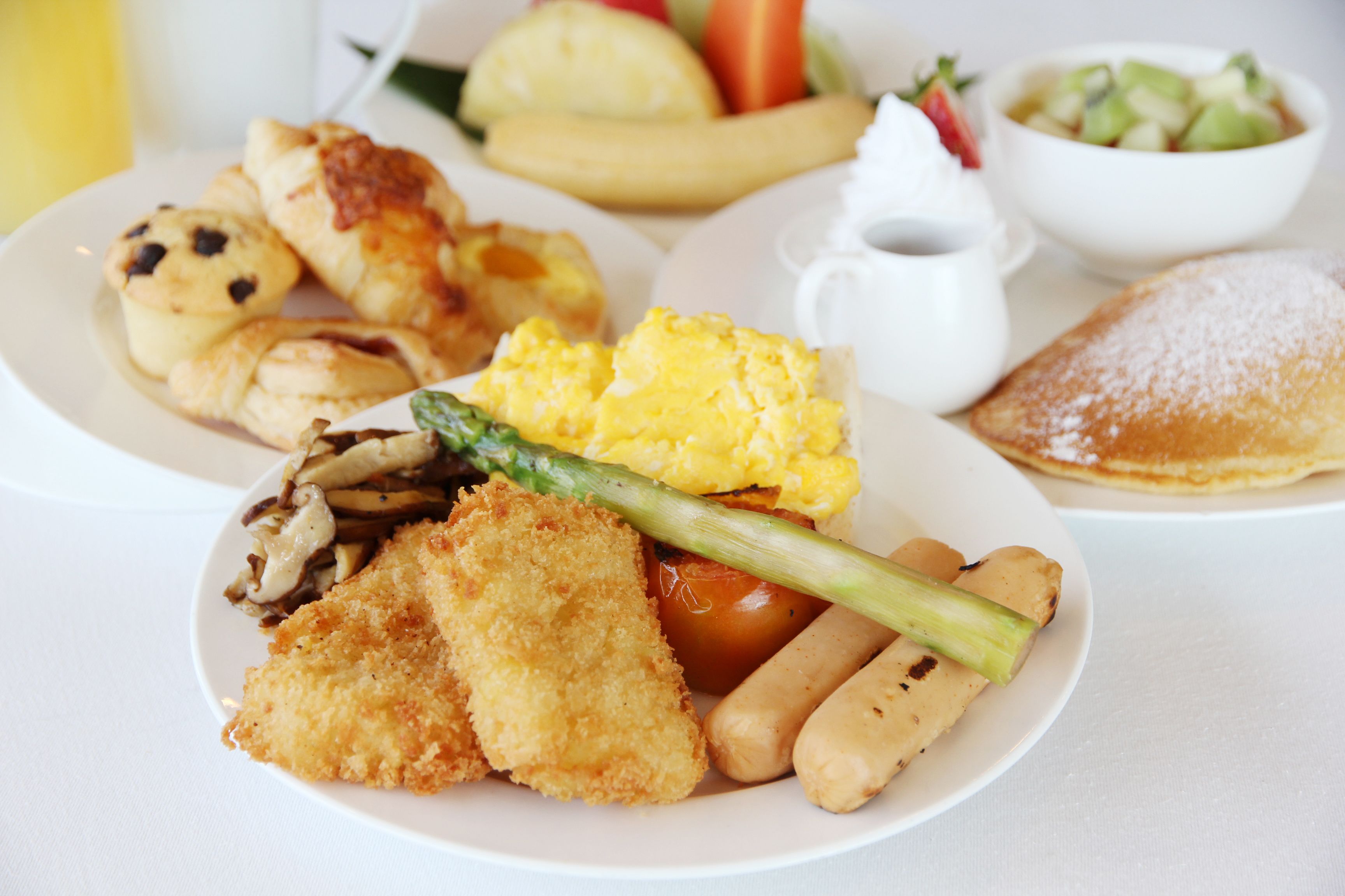 A plate with various foods including breaded chicken, asparagus, and potatoes.
