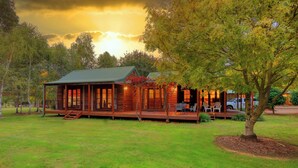 Eine Holzhütte mit Veranda, Essbereich und Blick auf den umliegenden Wald.