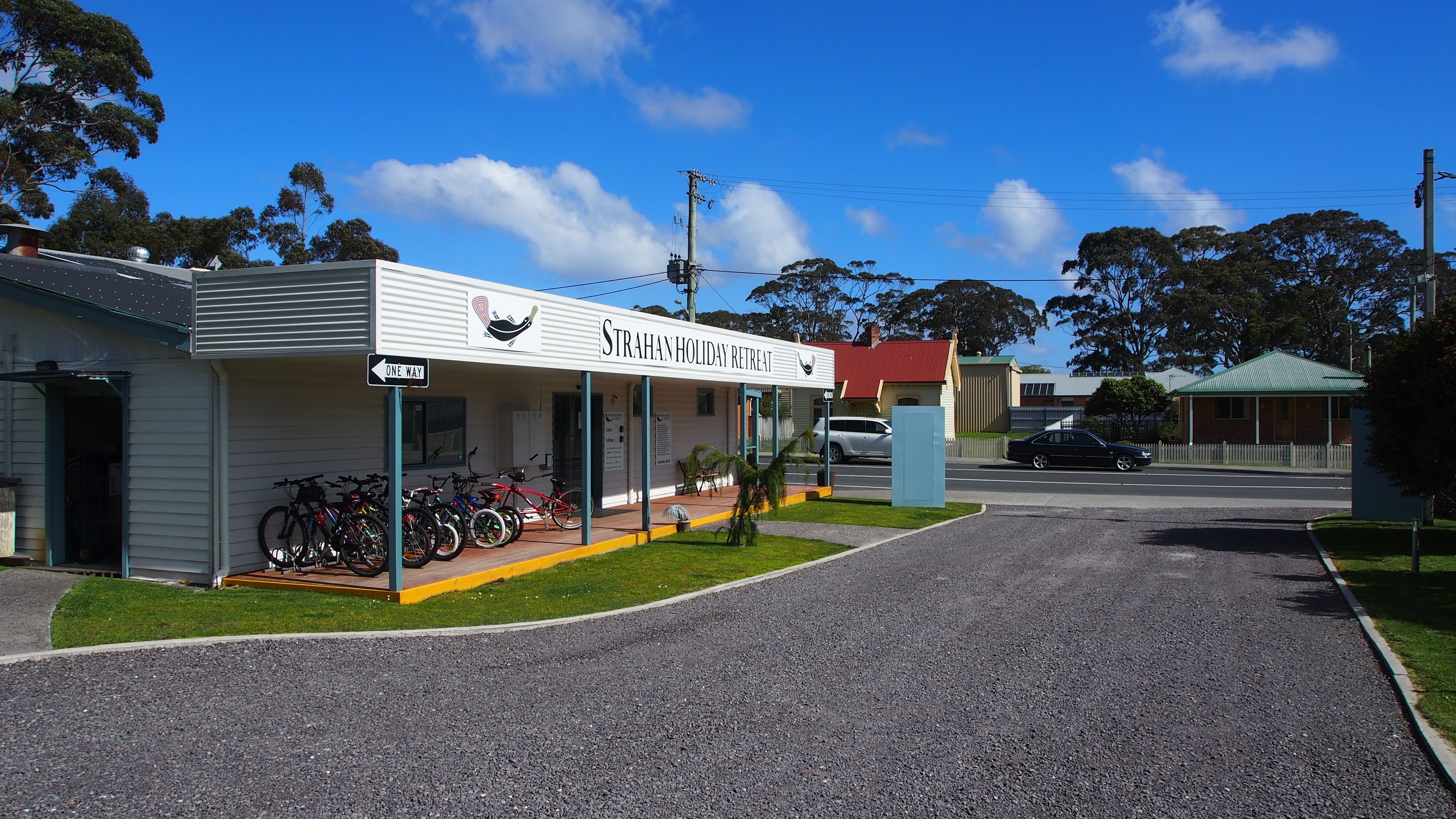 A building labeled "STRAHAN HOLIDAY RETREAT" with a one-way sign, a covered porch, and bicycles parked outside.