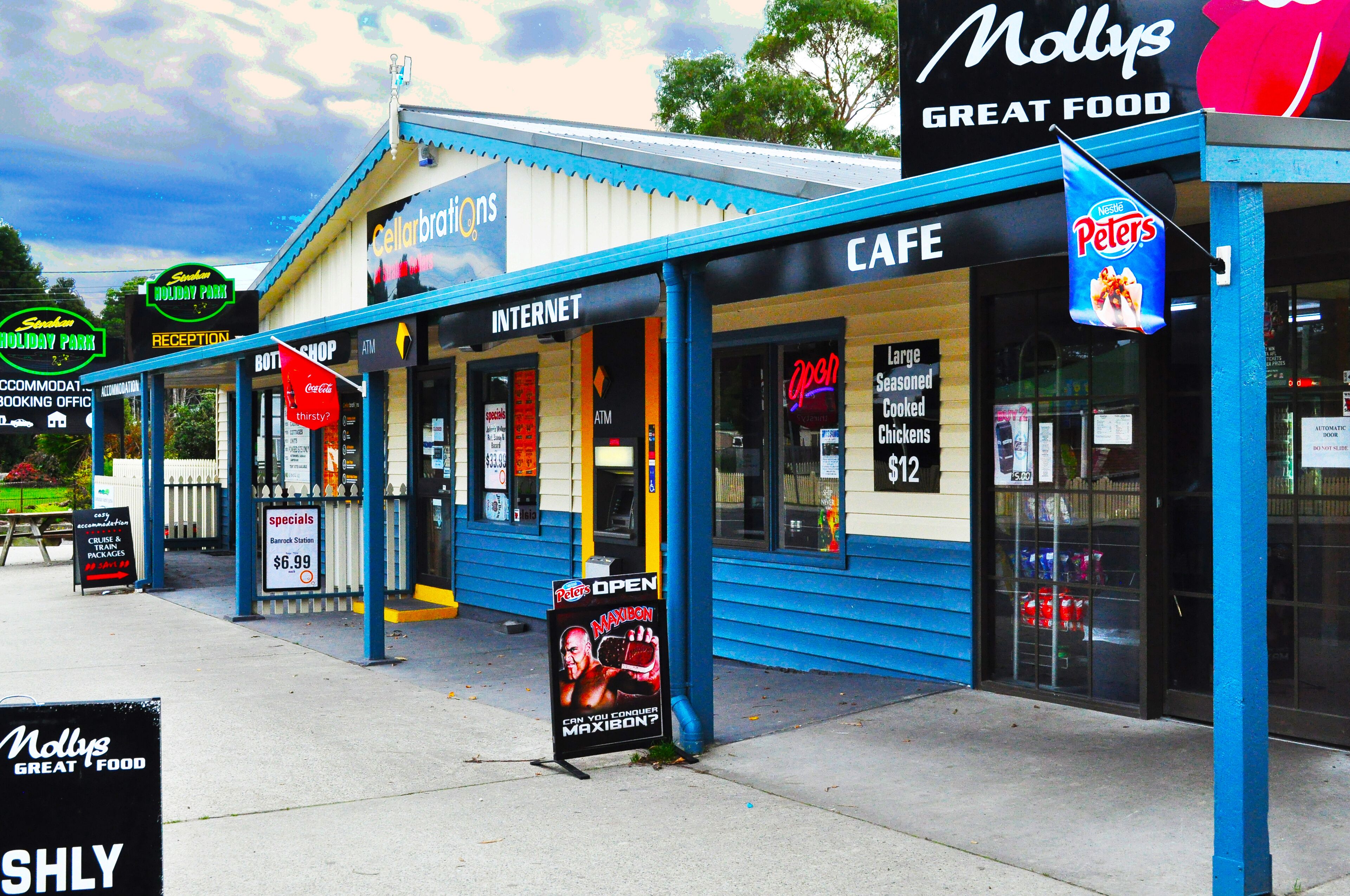 A building with a cafe, internet, and a sign for a holiday park.