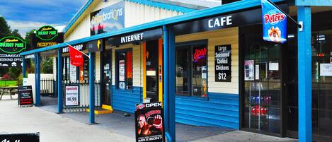 A building with a cafe, internet, and a sign for a holiday park.