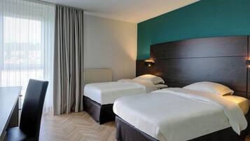 Una habitación de hotel con dos camas, un escritorio y una silla.