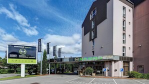Ein Bed & Breakfast Hotel mit modernem Design, einem überdachten Eingangsbereich und einem Parkplatz.