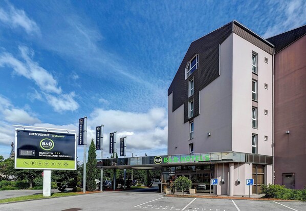 A B&B hotel with a modern design, a covered entrance, and a parking area.