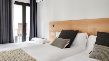 Una habitación de hotel con una cama grande, un cabecero de madera y una ventana con cortinas.
