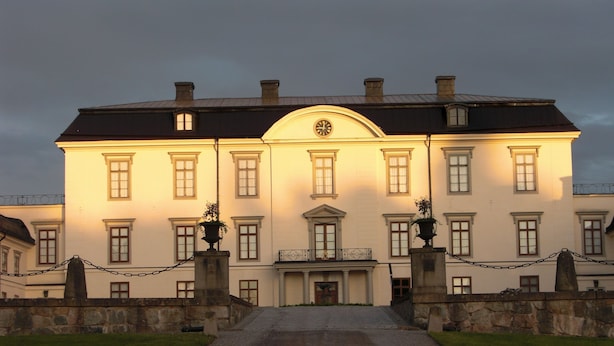 Un edificio grande y señorial con fachada simétrica, múltiples ventanas y una entrada central con un frontón decorativo.
