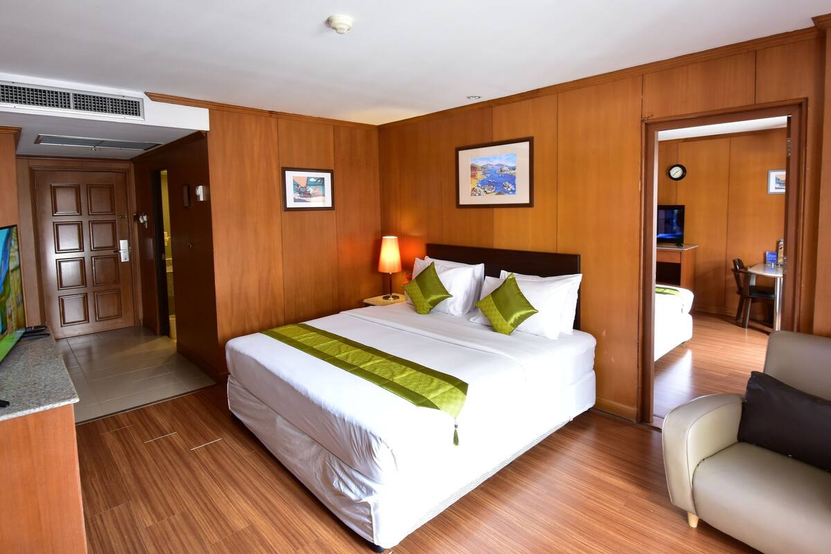 Une chambre d’hôtel dotée d’un grand lit, d’un bureau avec un téléviseur à écran plat, d’une chaise et d’un coin repas.