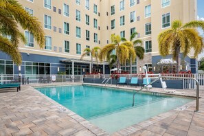 A hotel pool area with a clear pool, lounge chairs, and palm trees. - Staybridge Suites St. Petersburg Downtown by IHG (St. Petersburg)