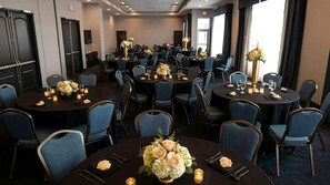 A conference room with multiple round tables, each set with chairs, candles, and floral centerpieces. - Staybridge Suites St. Petersburg Downtown by IHG (St. Petersburg)