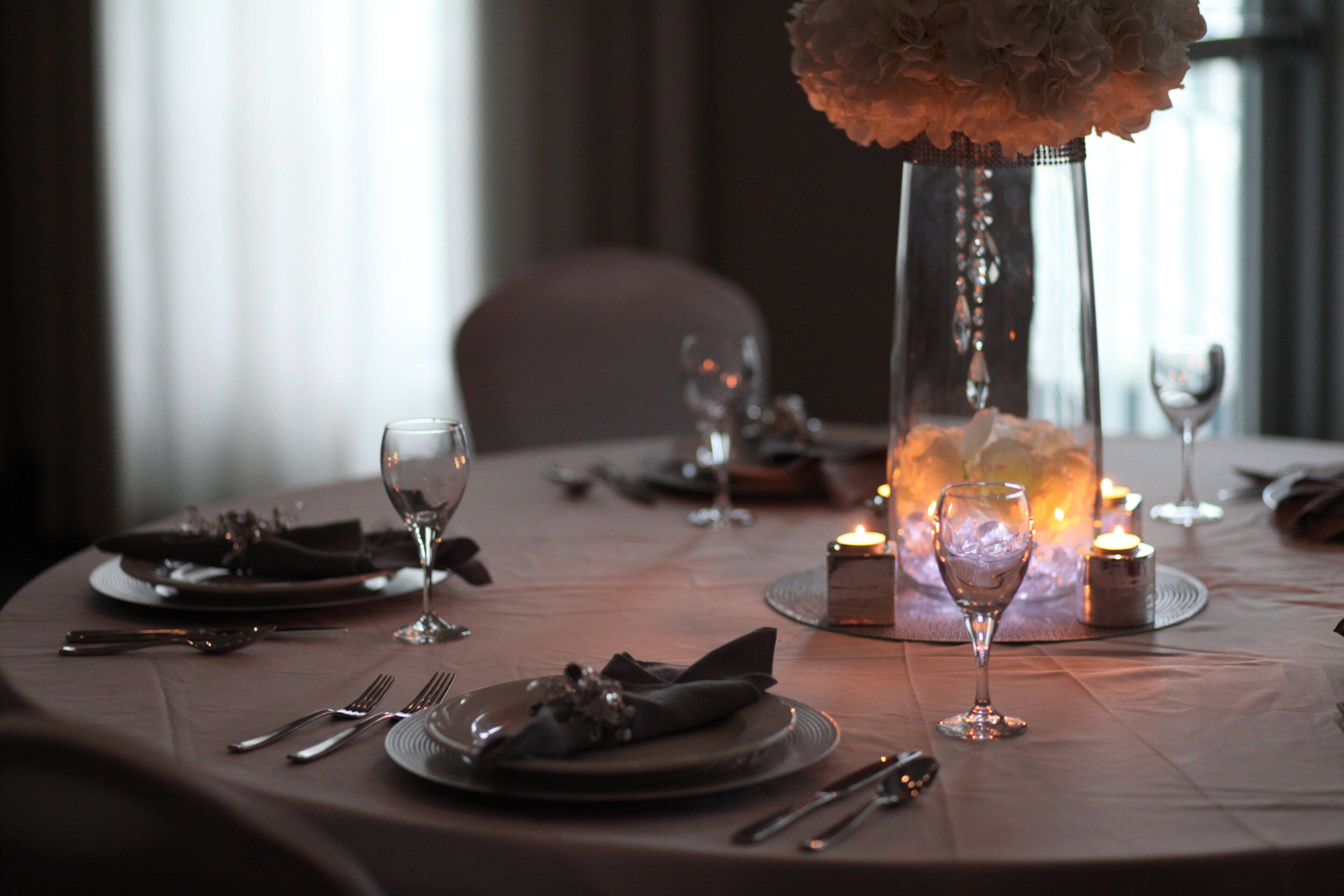 A table set for dining with candles, glasses, and cutlery.