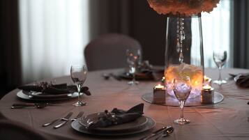 A table set for dining with candles, glasses, and cutlery.