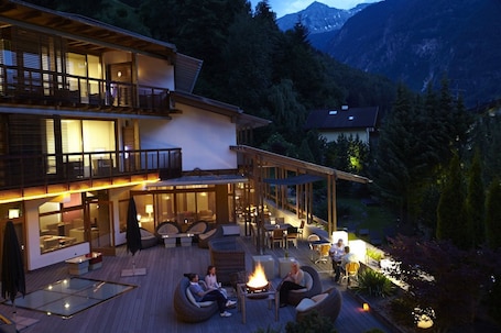 A two-story building with a patio area featuring outdoor seating and a fire pit.
