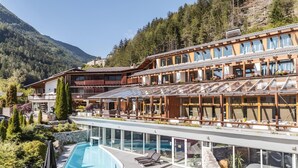 A modern hotel with a pool, wooden balconies, and mountain views. - Feldmilla Design Hotel – Wellness & SPA (Campo Tures)