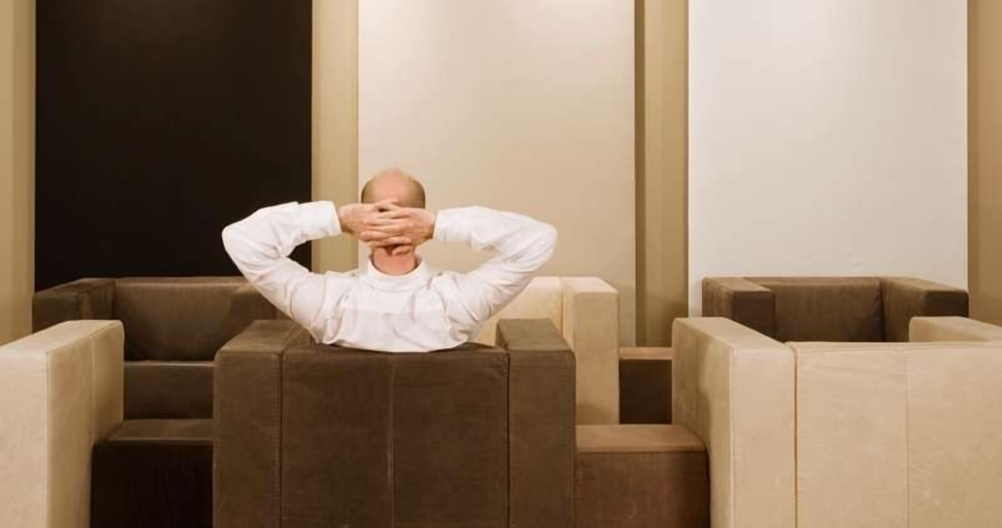 Une personne est assise dans un salon moderne et épuré, qui propose différents types de sièges.