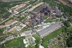 An industrial complex with multiple buildings, large chimneys, and extensive rail infrastructure. - Jugendherberge Duisburg Landschaftspark - Hostel (Duisburg)