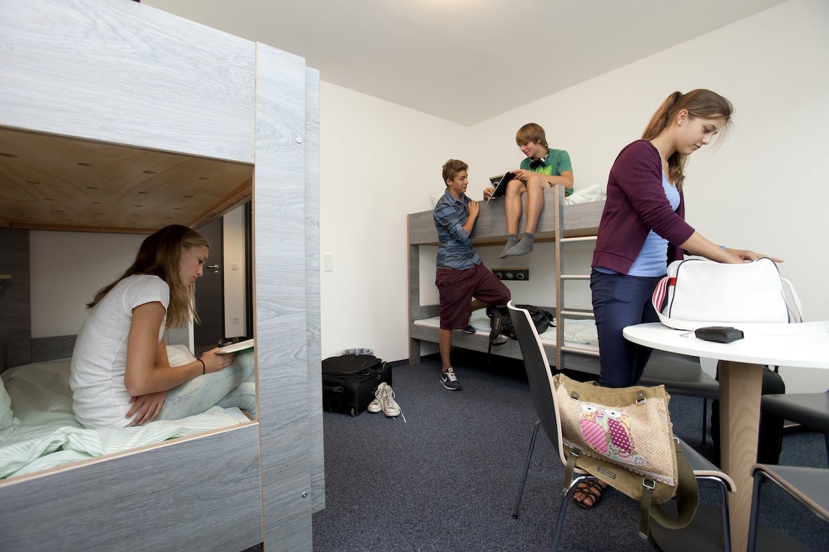 Un dormitorio con literas, un escritorio y una silla.