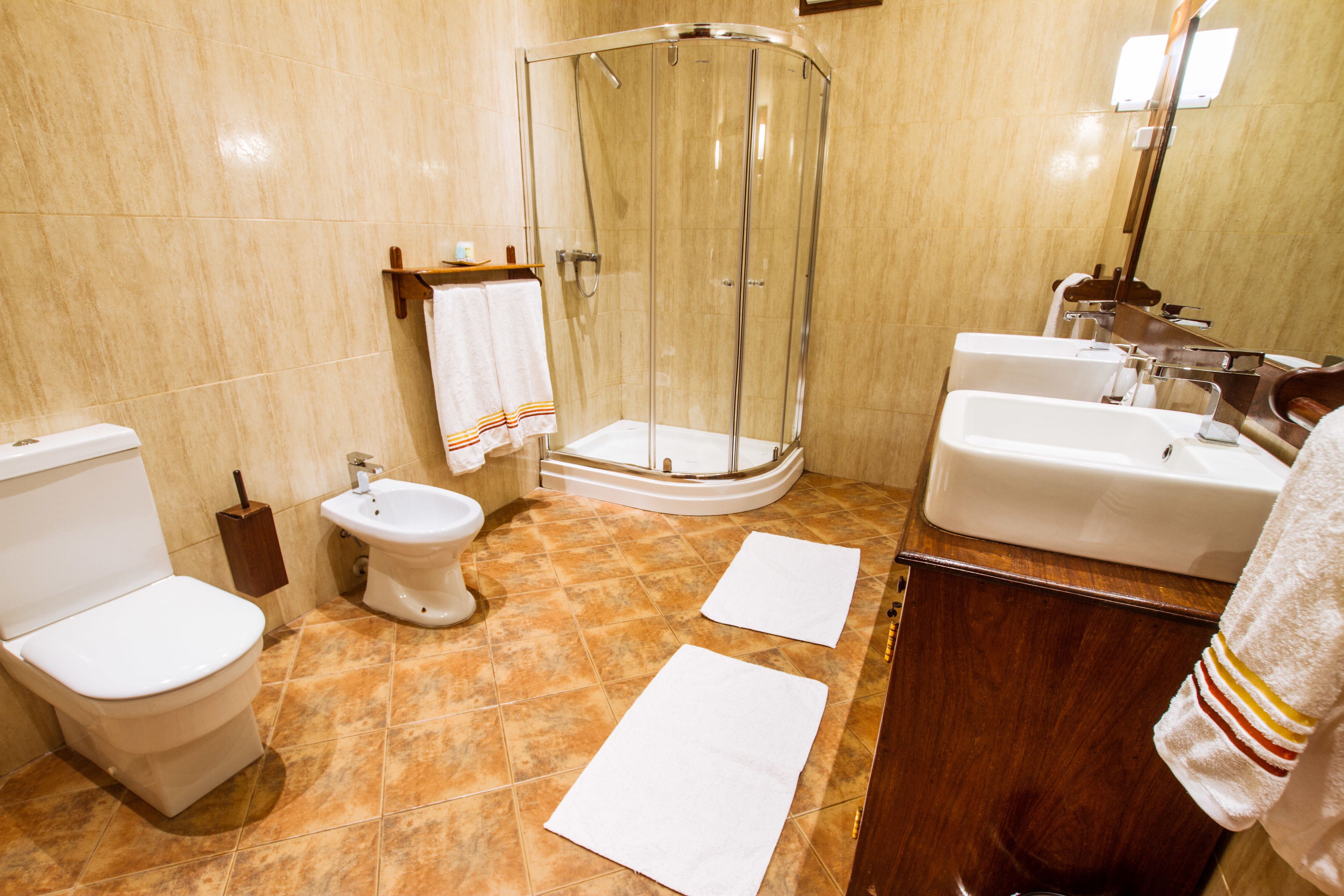 Une salle de bain équipée d’une douche, de toilettes, d’un bidet et d’un lavabo.