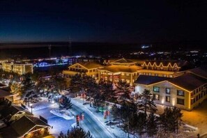 Ein großes Hotel mit mehreren Gebäuden, einem Innenhof und verschneiter Umgebung.