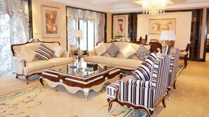 A luxurious living room with a sofa set, a coffee table, and striped armchairs. - Country Garden Phoenix Hotel Huiyang (Huizhou)
