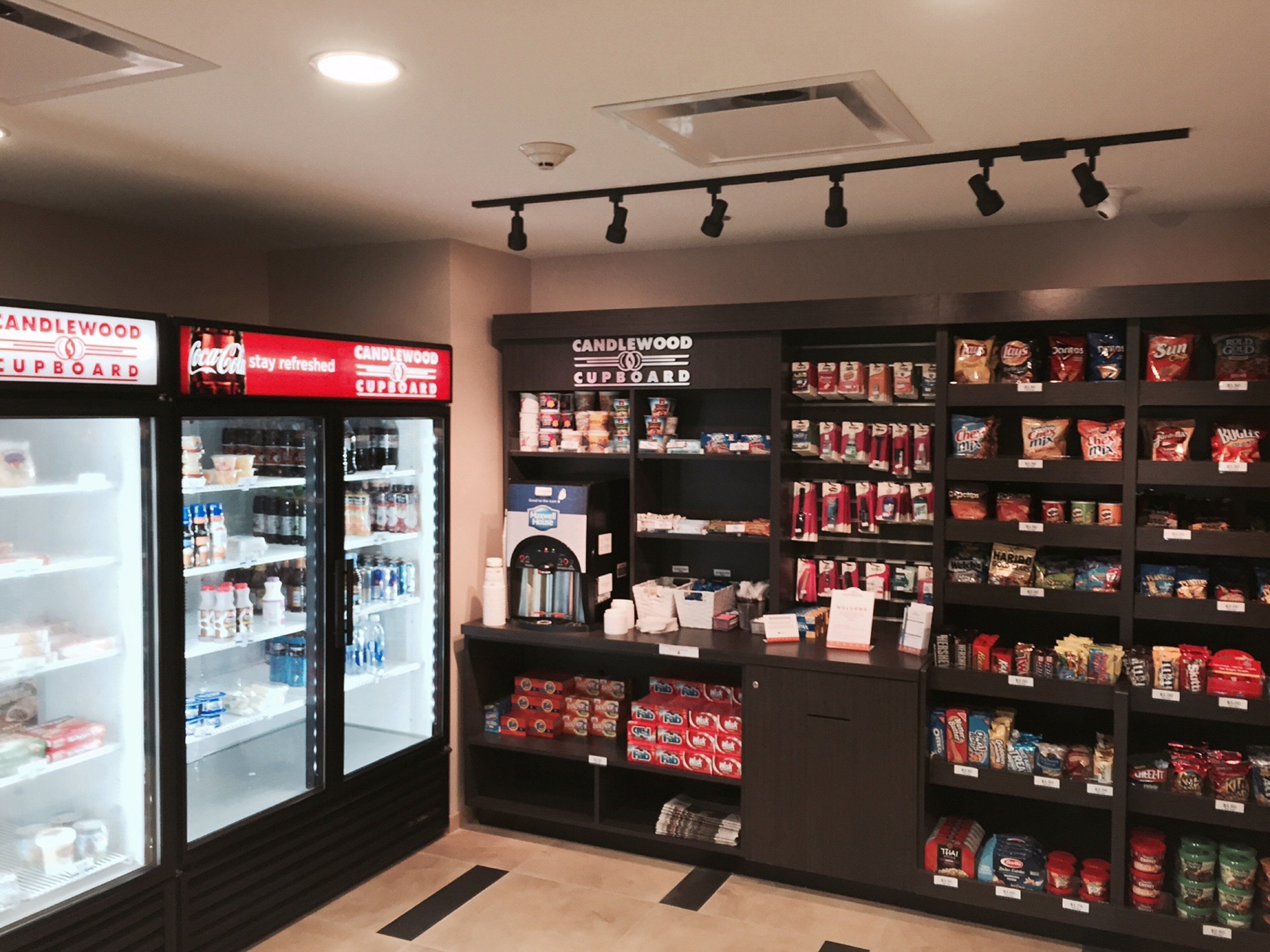 A convenience store with refrigerated sections and shelves stocked with snacks and beverages.
