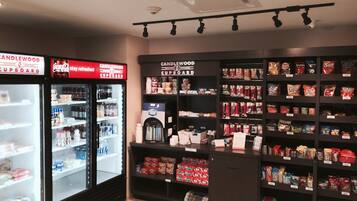 A convenience store with refrigerated sections and shelves stocked with snacks and beverages.
