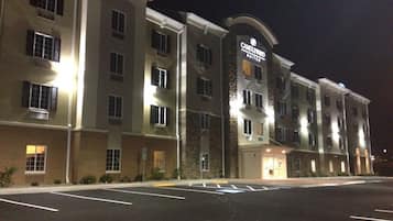 Un hotel de varios pisos con una entrada destacada y un letrero que indica que es un Candlewood Suites.