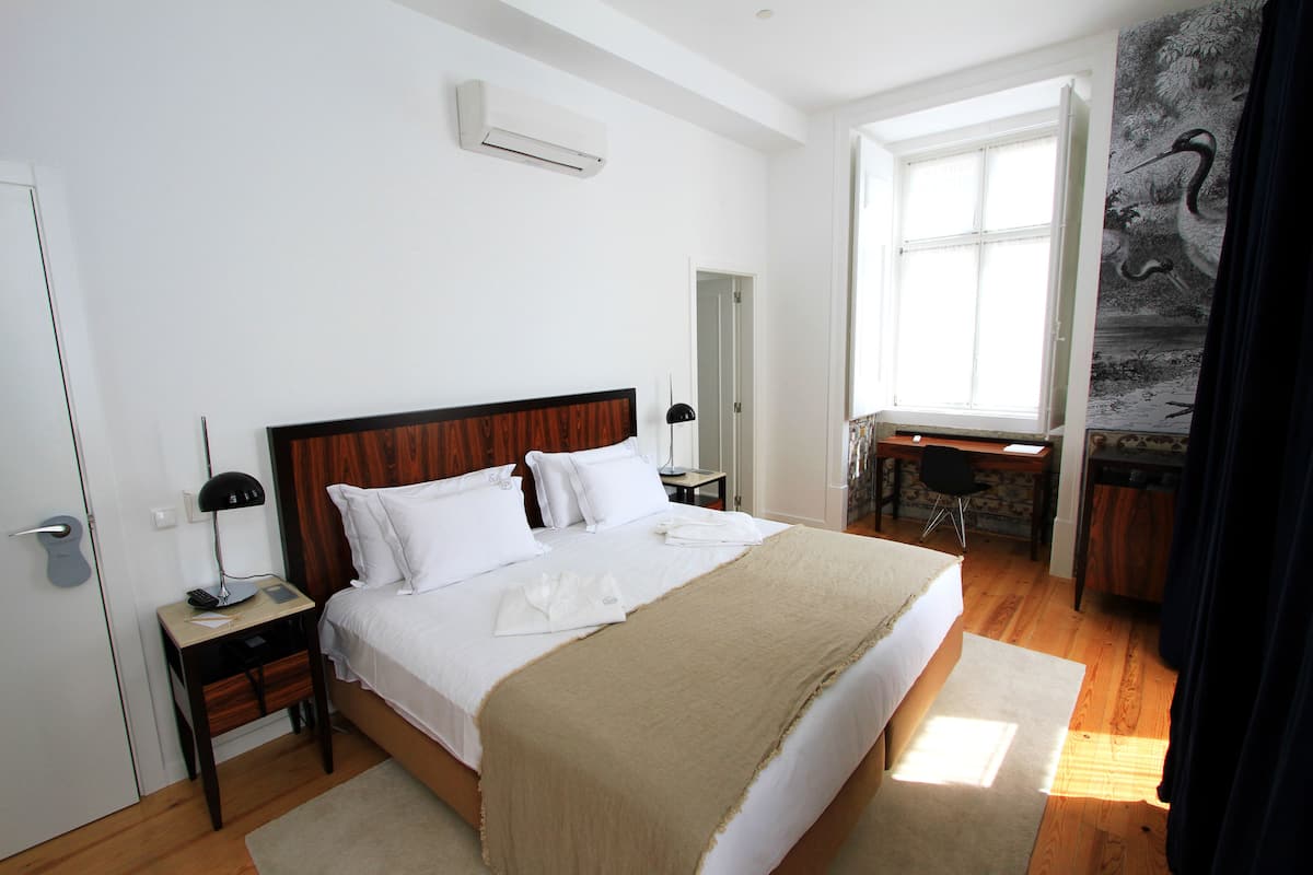 A bedroom with a large bed, a desk, and a chair.