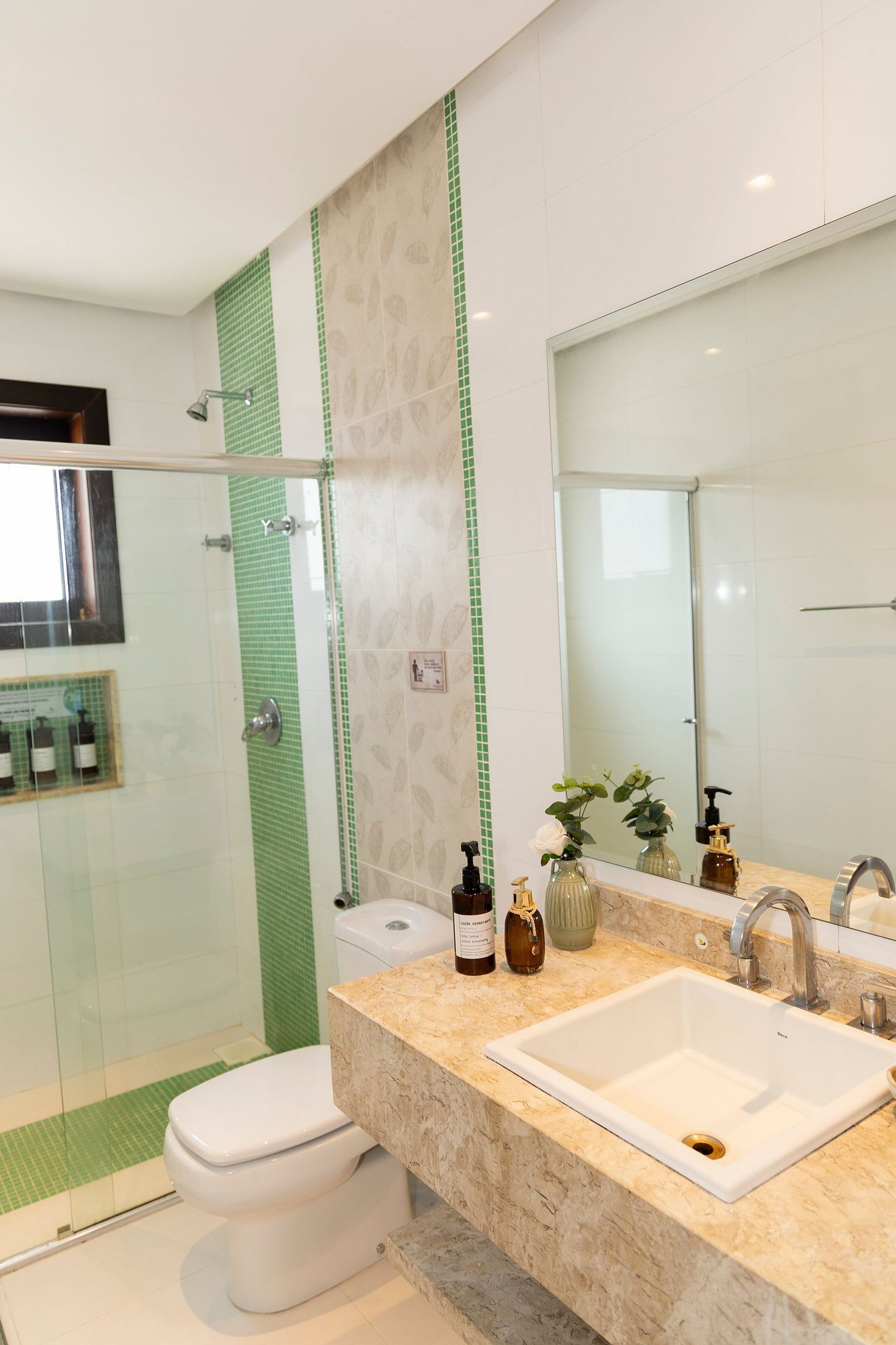 A bathroom with a white sink, a mirror, and a shower with a glass door.
