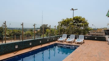 Alberca al aire libre y camastros