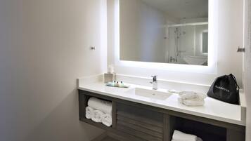 A modern bathroom with a large mirror, dual sinks, and a towel rack.