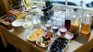 A breakfast buffet table with various food items and beverages. - Ashleigh House (Torquay)