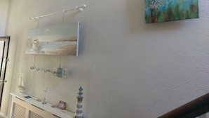Una habitación con temática náutica, que incluye un modelo de barco, un faro y una pintura marina.
