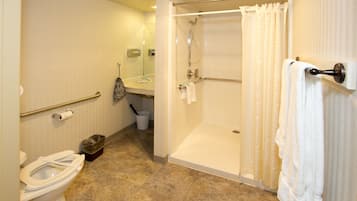 A bathroom with a toilet, a shower, and a sink.
