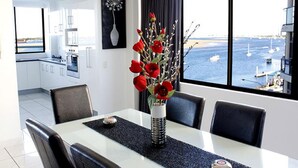 A dining area with a view of the sea and boats. - Beaconlea Tower Apartments (Labrador)