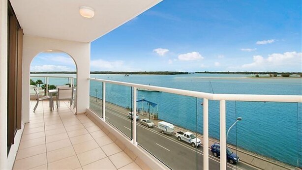 A balcony with a view of a body of water and a road with vehicles. - Beaconlea Tower Apartments (Labrador)