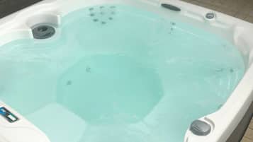 Un jacuzzi con panel de control y desagüe.