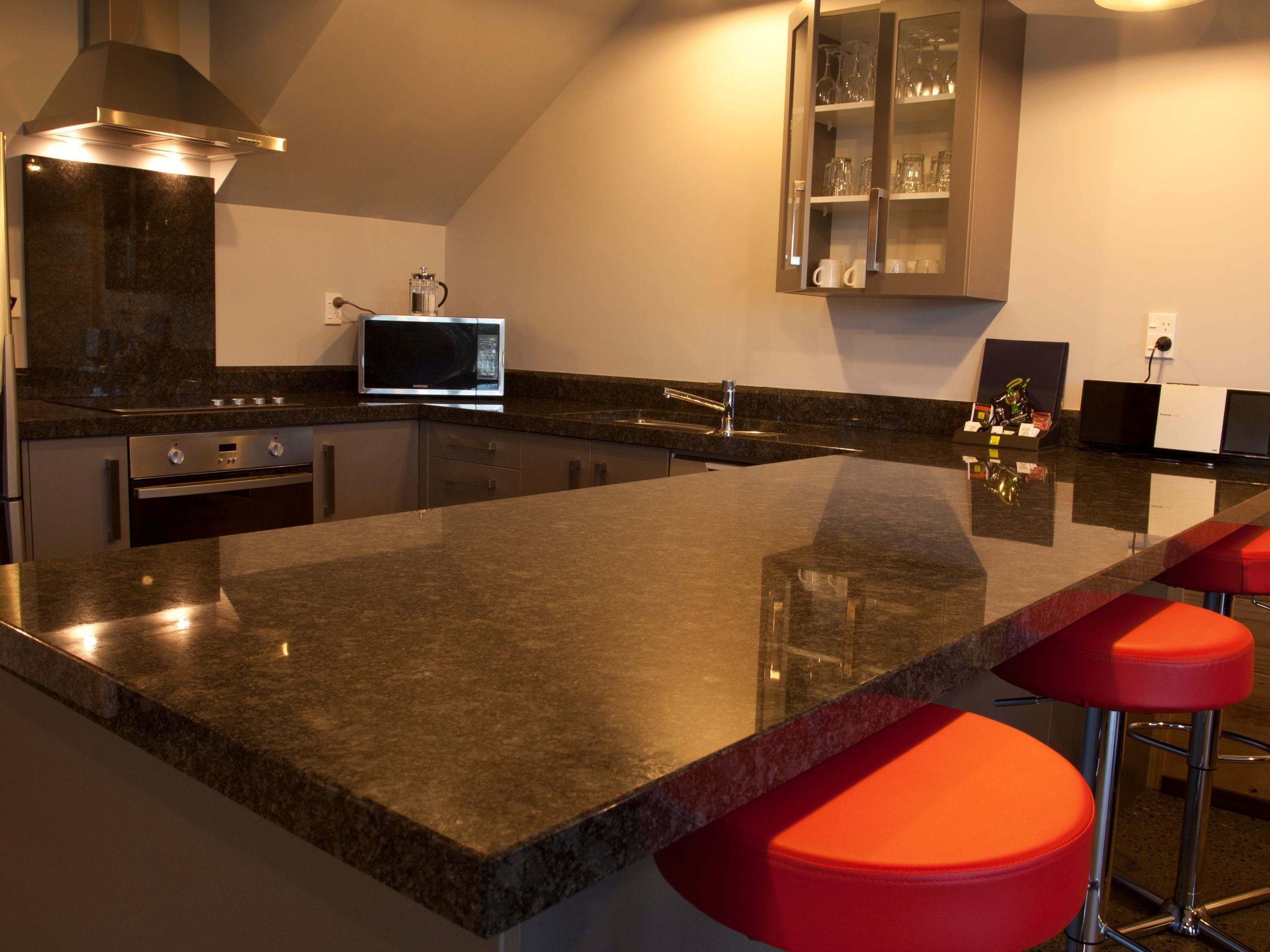 A modern kitchen with granite countertops, stainless steel appliances, and a built-in microwave.
