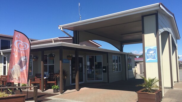 A building with a reception area, a sign indicating 'Top 10 Holiday Fares', and a flag with a heart symbol.