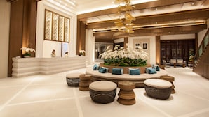 A spacious lobby with a central seating area, a reception desk, and a staircase. - Areca Lodge (Pattaya)