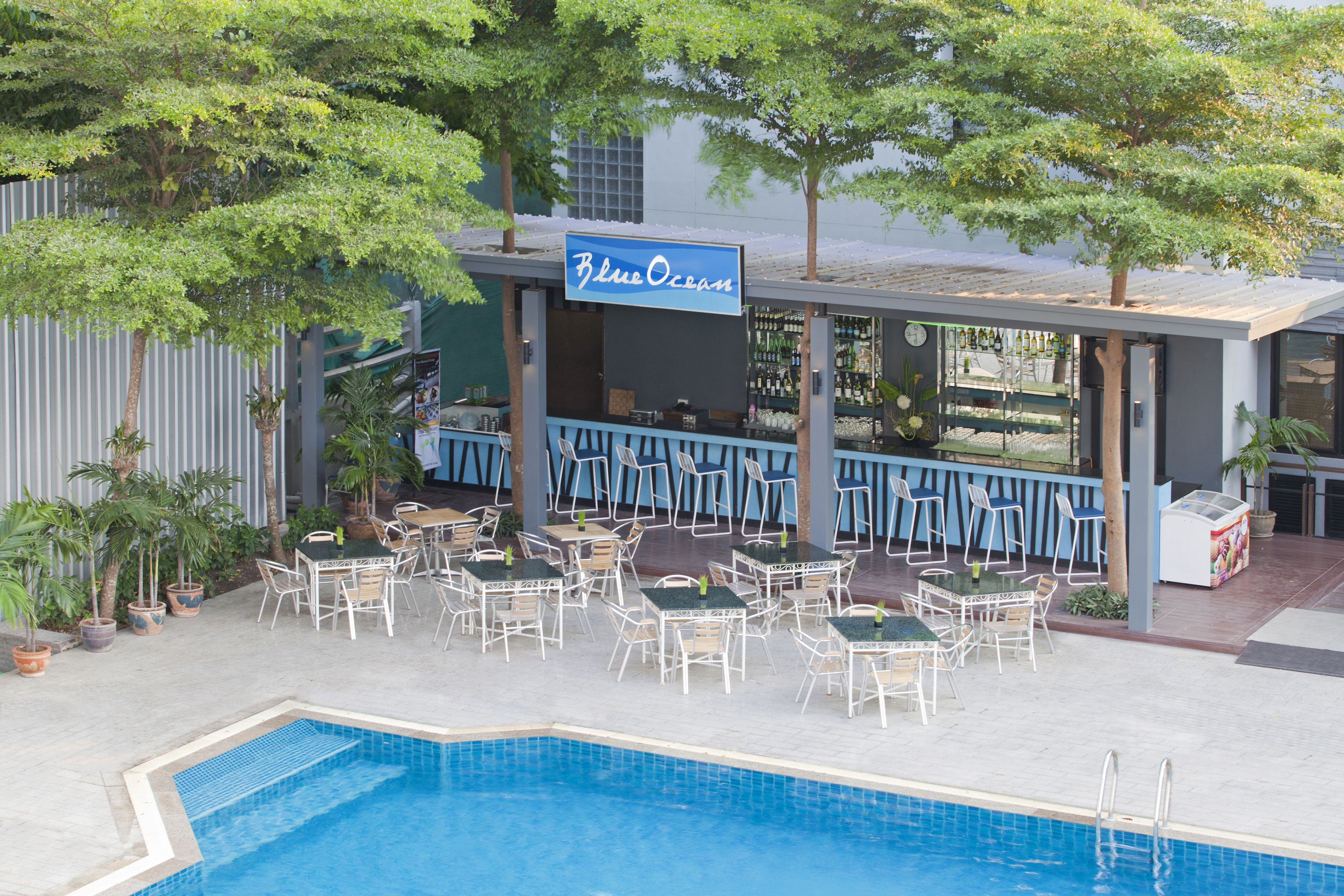 A poolside area with outdoor seating and a bar.