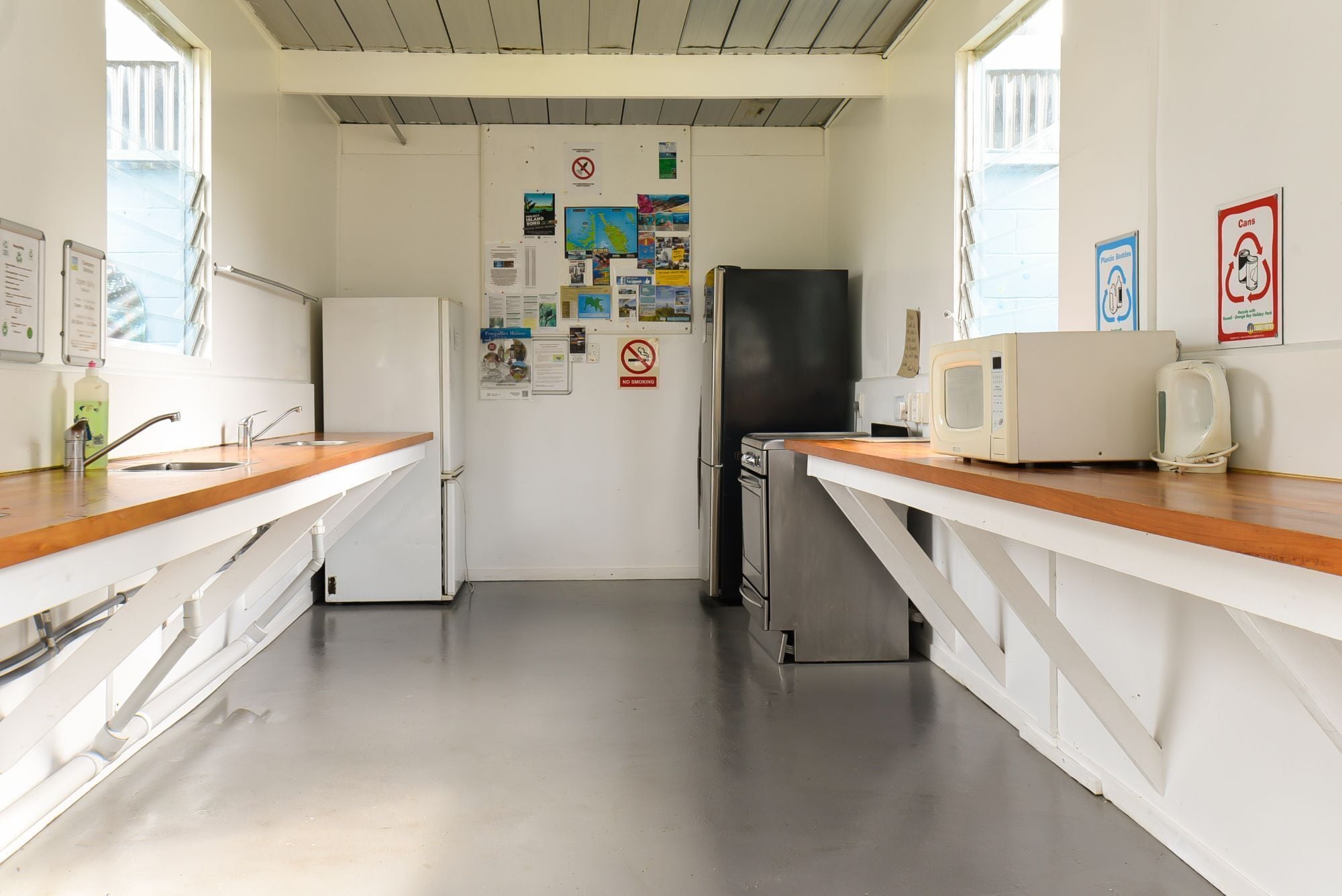 A kitchen with white cabinets, stainless steel appliances, and a wooden countertop.