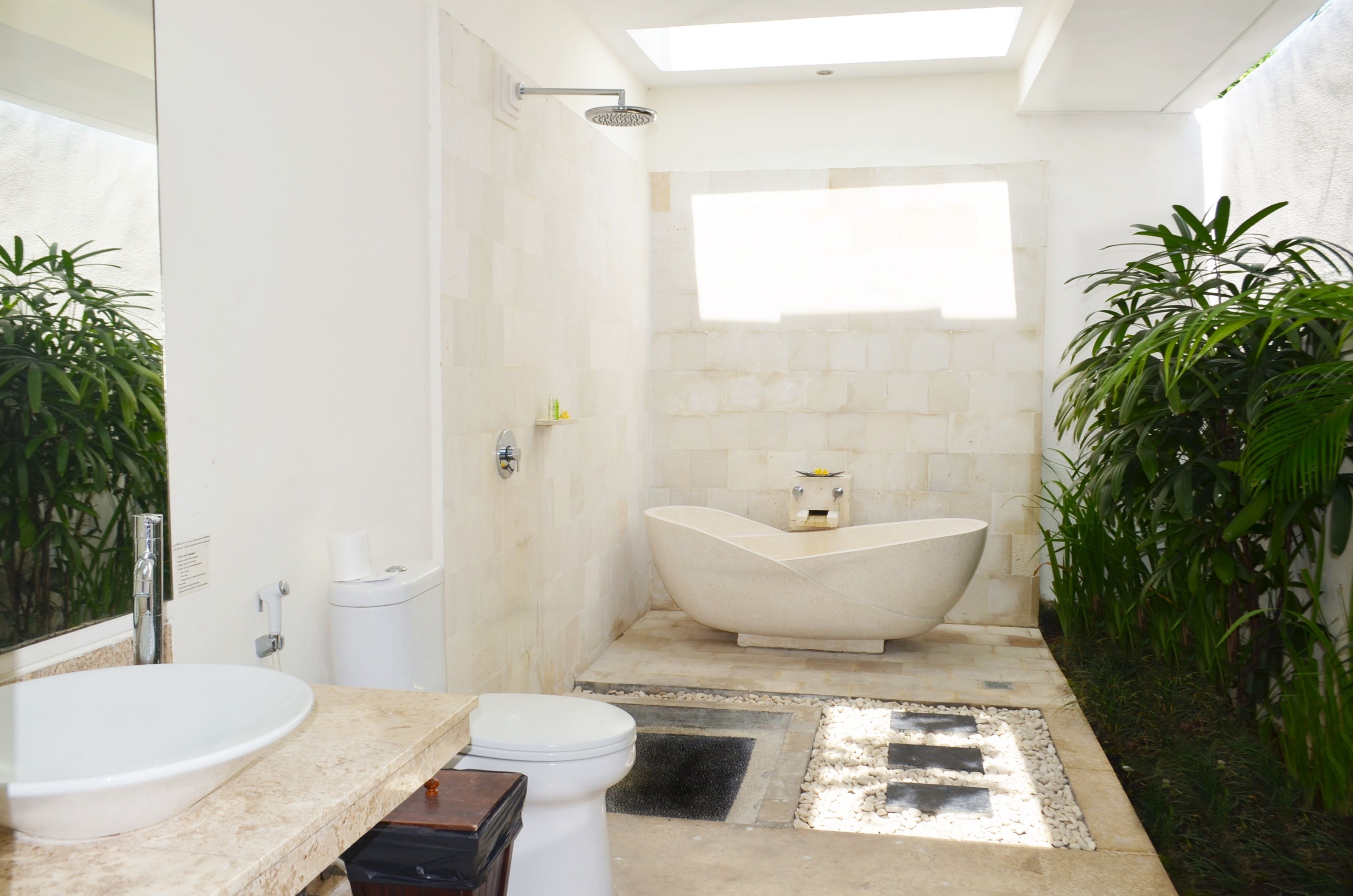 Une salle de bain moderne avec une baignoire sur pieds, un grand miroir et un lavabo.